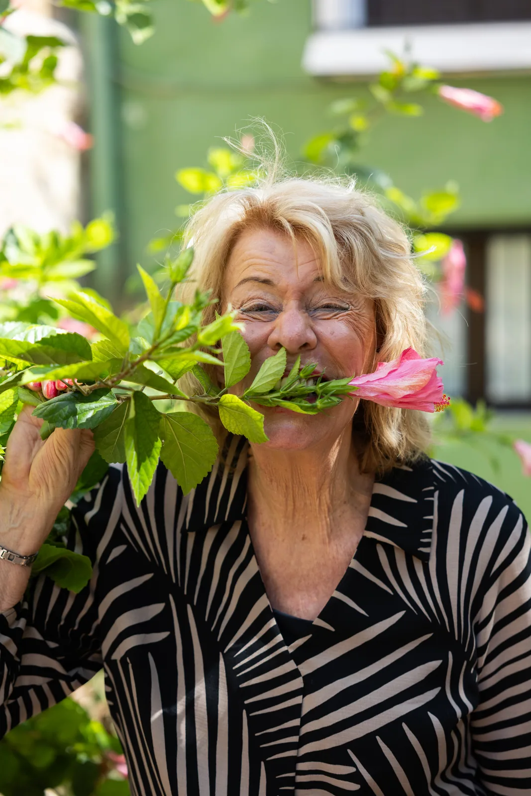 Jessica Larive houdt lachend een bloem tussen haar tanden