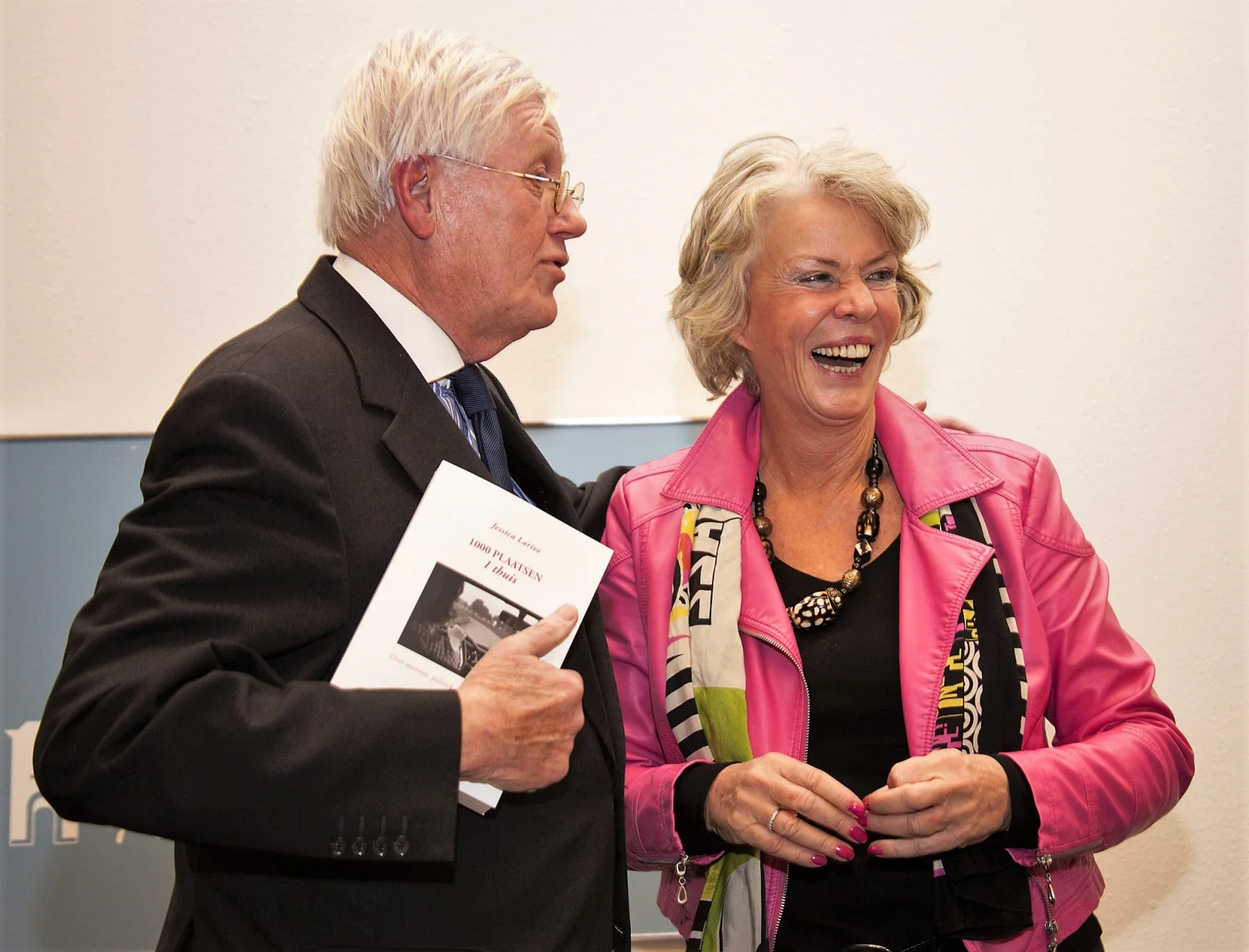 Jessica Larive lachend met Wim Wiegel en haar boek 1000 plaatsen, 1 thuis