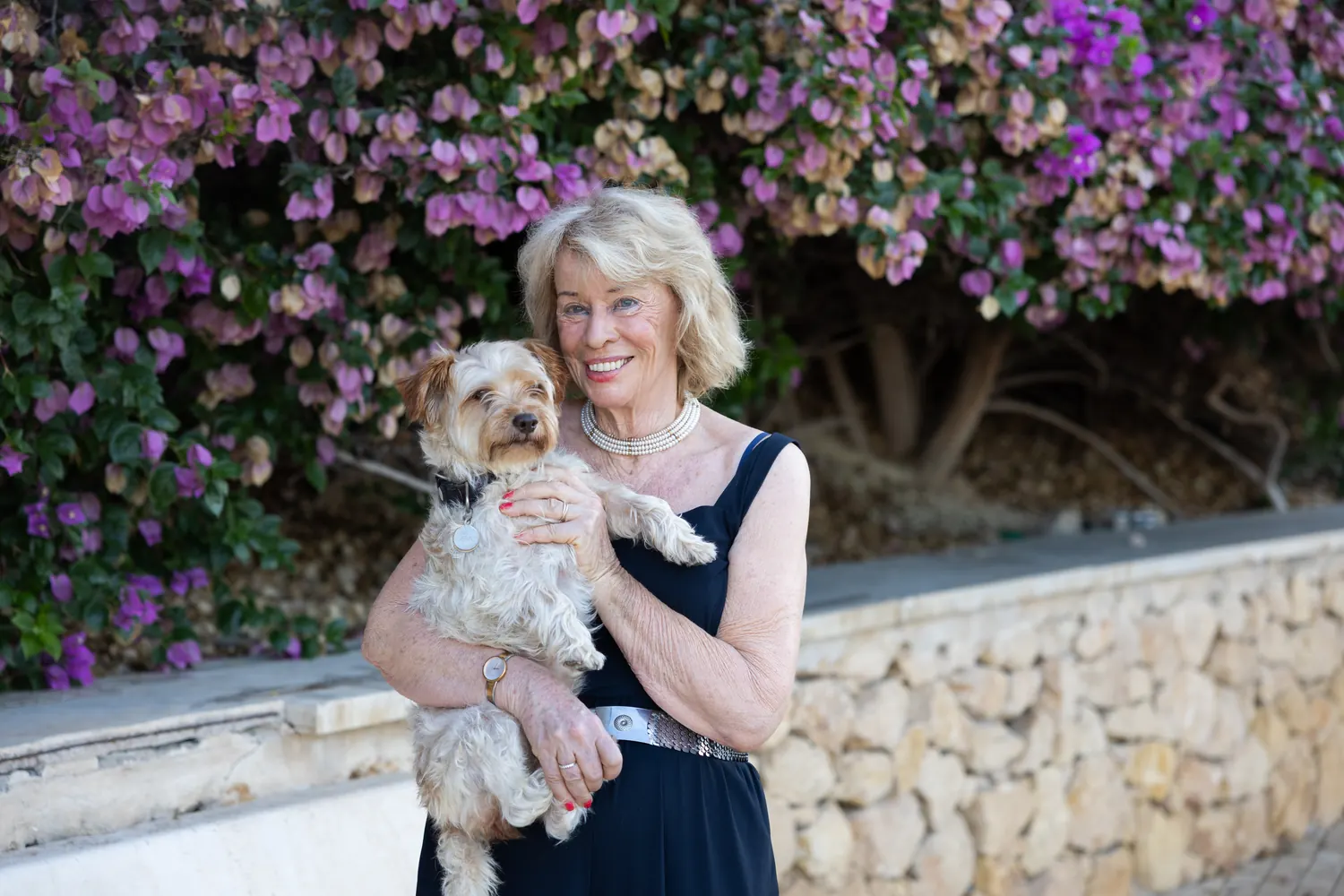 Jessica Larive met haar hond voor een bloeiende bougainville
