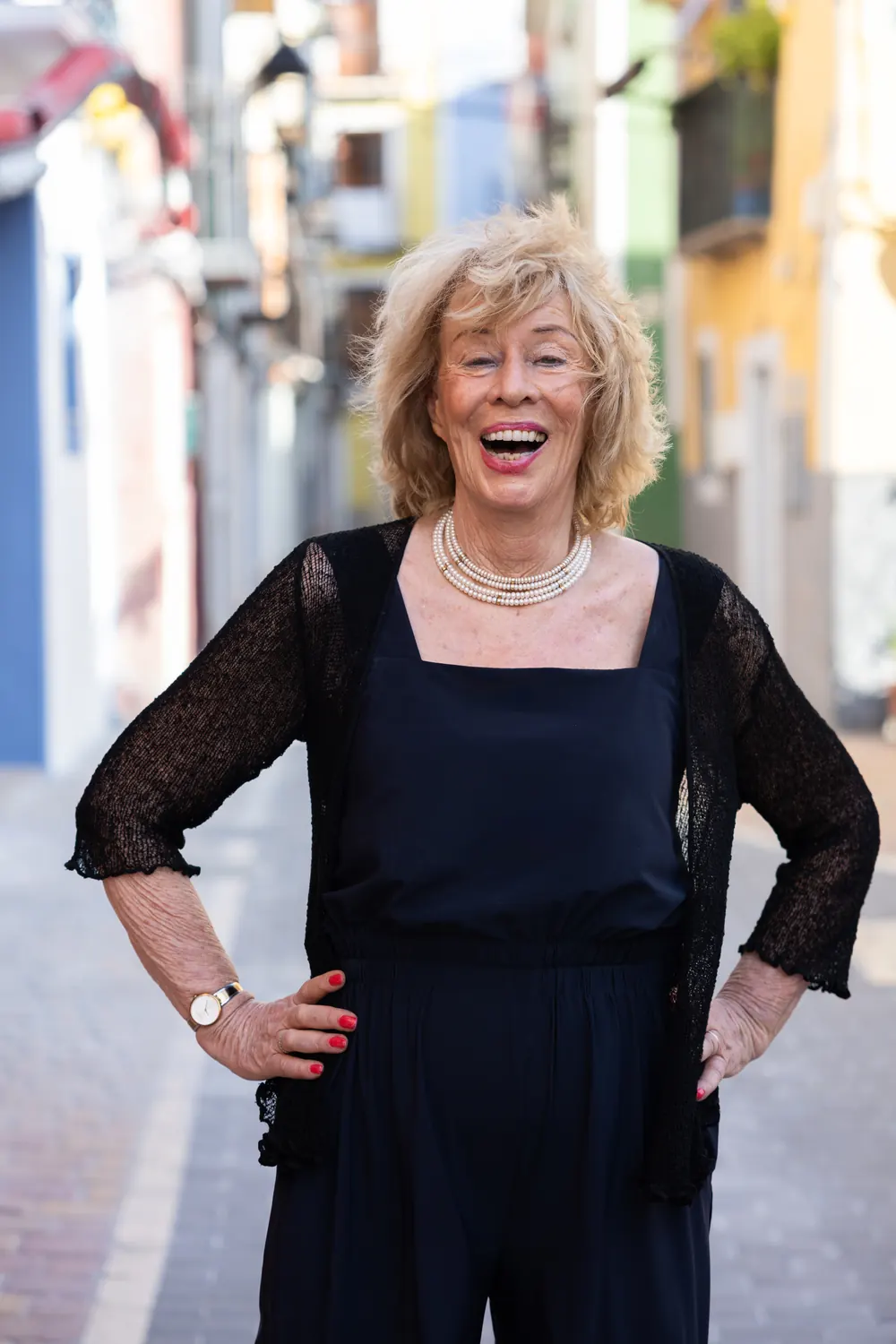 Jessica Larive lacht, in het zwart, met haar handen in de zij