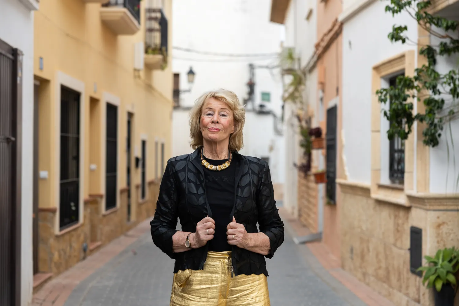 Jessica Larive in een zwarte leren jas in een smalle straat