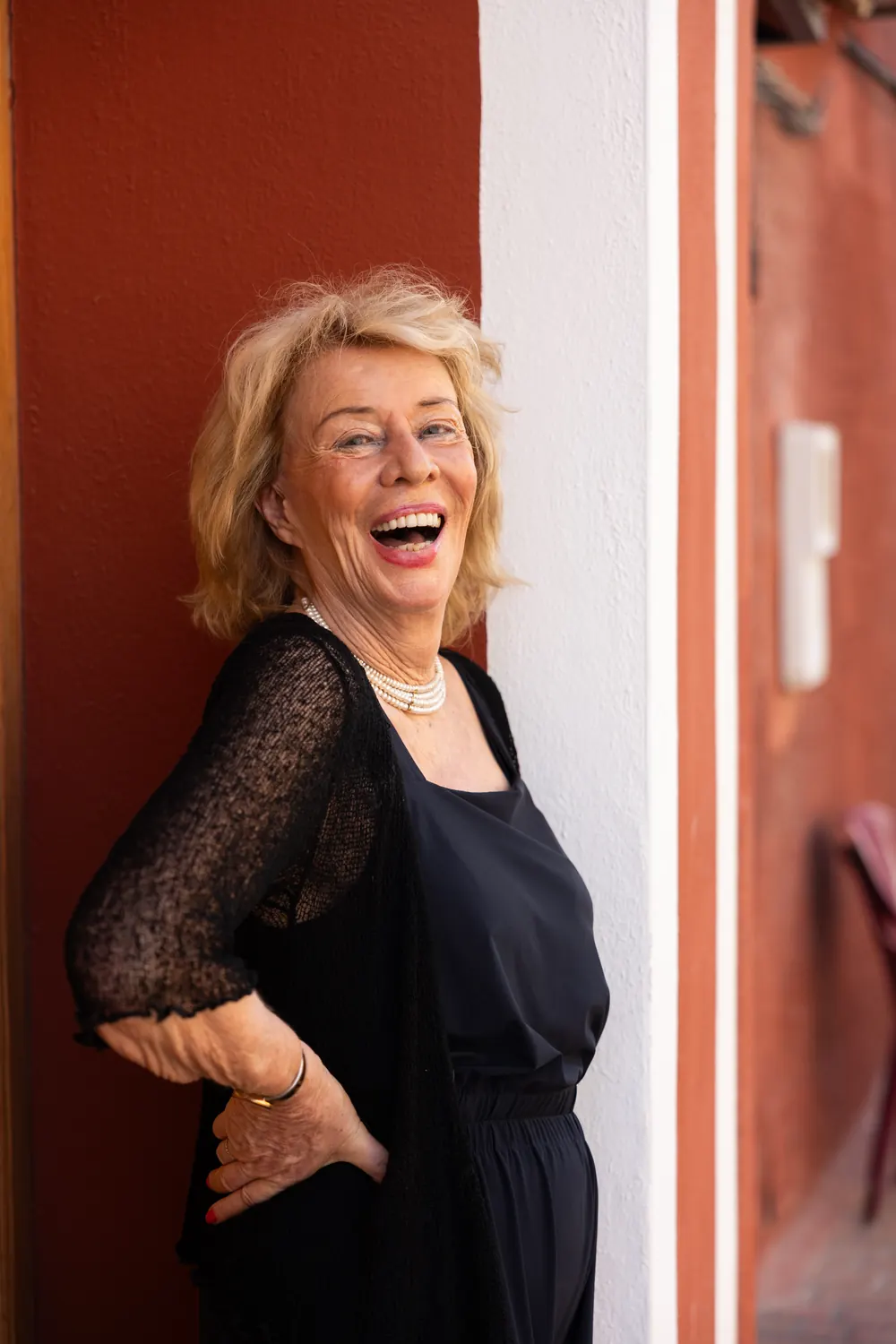 Jessica Larive lacht tegen een rode muur